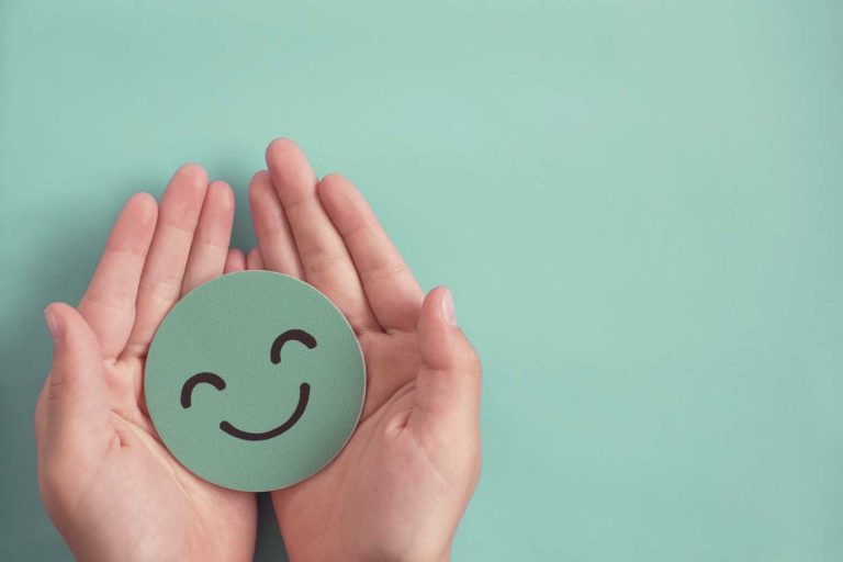 Green smiley face in hands